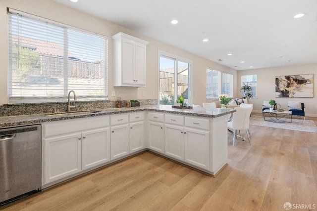 kitchen with sink, white cabinetry, dishwasher, and light hardwood / wood-style flooring