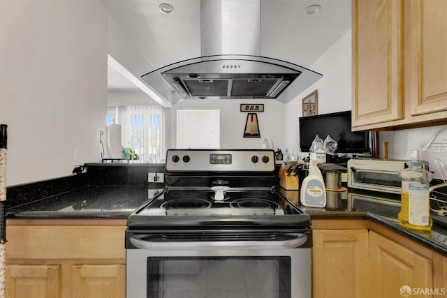 kitchen with dark stone counters, light brown cabinetry, island range hood, and stainless steel electric range oven