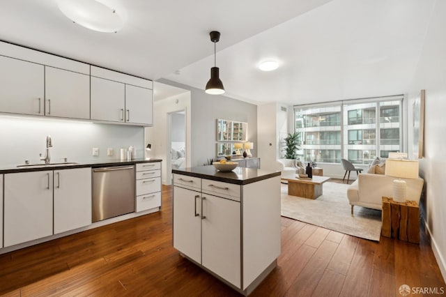 kitchen featuring pendant lighting, sink, stainless steel dishwasher, and white cabinets