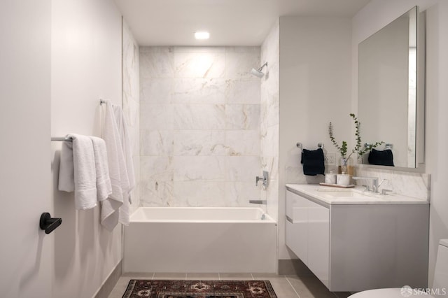 full bathroom featuring tiled shower / bath combo, vanity, tile patterned floors, and toilet