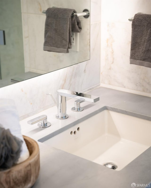 bathroom with sink, decorative backsplash, and a shower