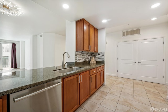 423 7th St Unit 303, Oakland, CA 94607 - kitchen with dishwasher, brown cabinetry, dark stone countertops, backsplash, and light tile patterned floors