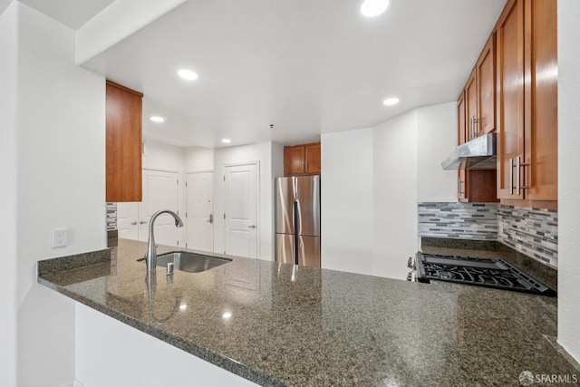 423 7th St Unit 303, Oakland, CA 94607 - kitchen featuring freestanding refrigerator, under cabinet range hood, a peninsula, gas stove, and dark stone counters