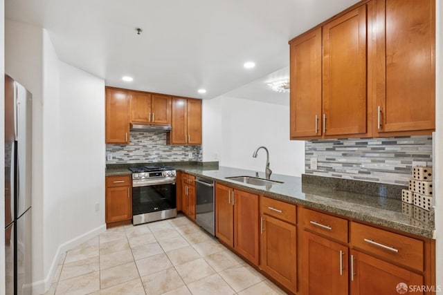 423 7th St Unit 303, Oakland, CA 94607 - kitchen featuring stainless steel appliances, brown cabinets, backsplash, light tile patterned flooring, and under cabinet range hood