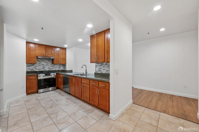 423 7th St Unit 303, Oakland, CA 94607 - kitchen with appliances with stainless steel finishes, under cabinet range hood, recessed lighting, backsplash, and brown cabinets