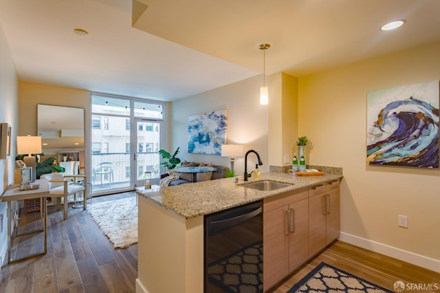 55 Page St Unit 428, San Francisco, CA 94102 - kitchen featuring dishwasher, a sink, a peninsula, dark wood-type flooring, and light stone counters