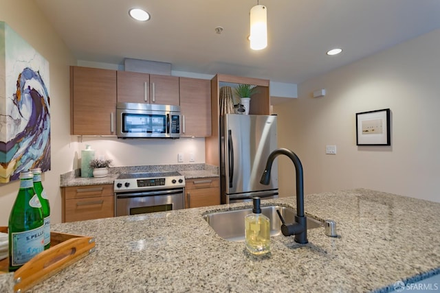 55 Page St Unit 428, San Francisco, CA 94102 - kitchen with stainless steel appliances, brown cabinets, a sink, light stone counters, and recessed lighting