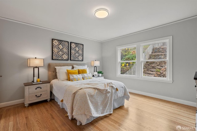bedroom with baseboards and wood finished floors