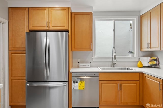 kitchen with stainless steel appliances, a sink, and light countertops
