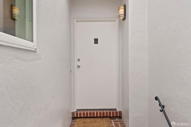 doorway to property featuring stucco siding