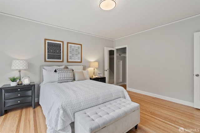 bedroom with light wood-style floors, baseboards, and crown molding