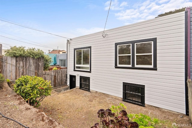 rear view of property featuring fence