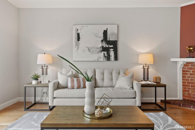 living area with baseboards, wood finished floors, and crown molding