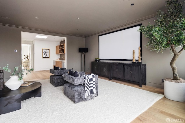 home theater room with bar, crown molding, and wood-type flooring