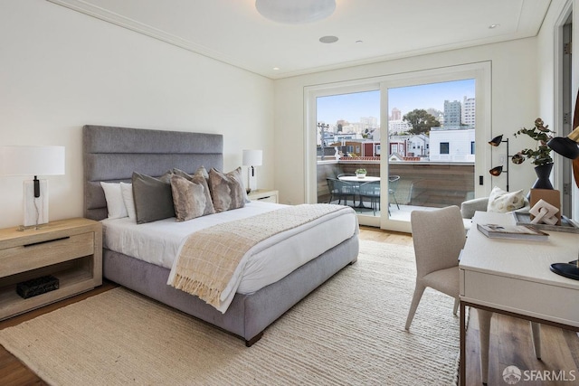 bedroom with wood-type flooring and access to exterior