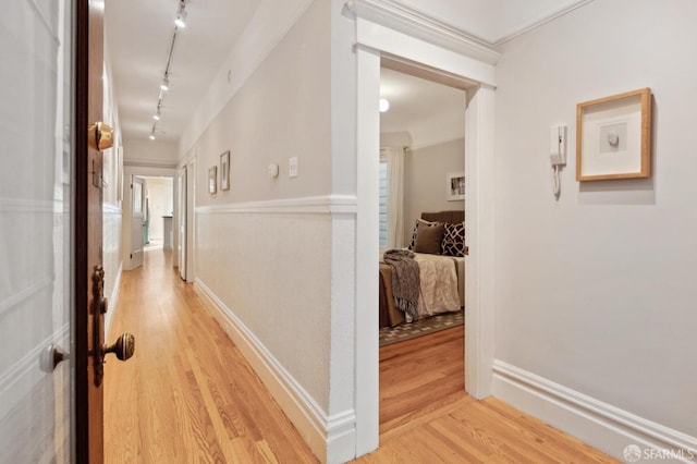 hallway featuring track lighting and light hardwood / wood-style floors