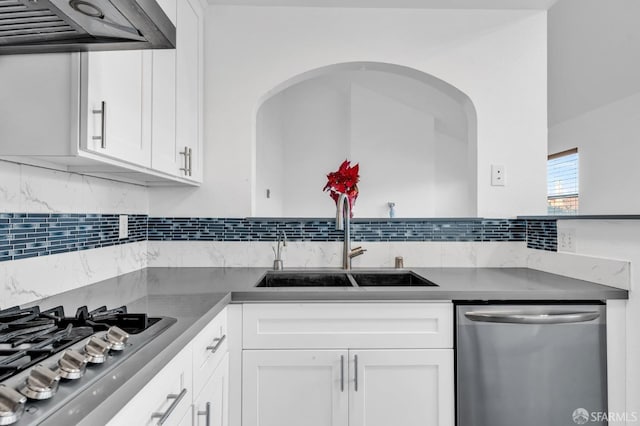 kitchen featuring white cabinets, appliances with stainless steel finishes, sink, backsplash, and ventilation hood