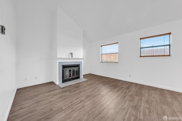 unfurnished living room featuring vaulted ceiling, a fireplace, and hardwood / wood-style flooring