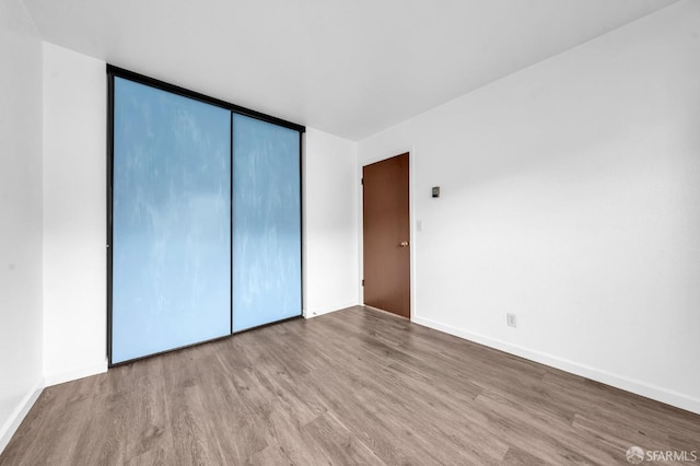 unfurnished bedroom with a closet and light hardwood / wood-style flooring