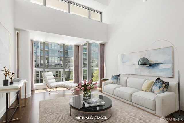 living room featuring floor to ceiling windows, hardwood / wood-style floors, and a high ceiling