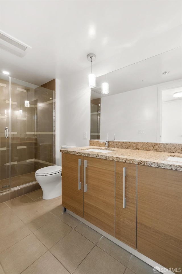 bathroom featuring vanity, toilet, an enclosed shower, and tile patterned flooring