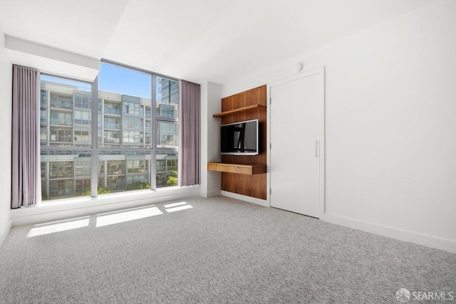 unfurnished living room featuring plenty of natural light and light colored carpet