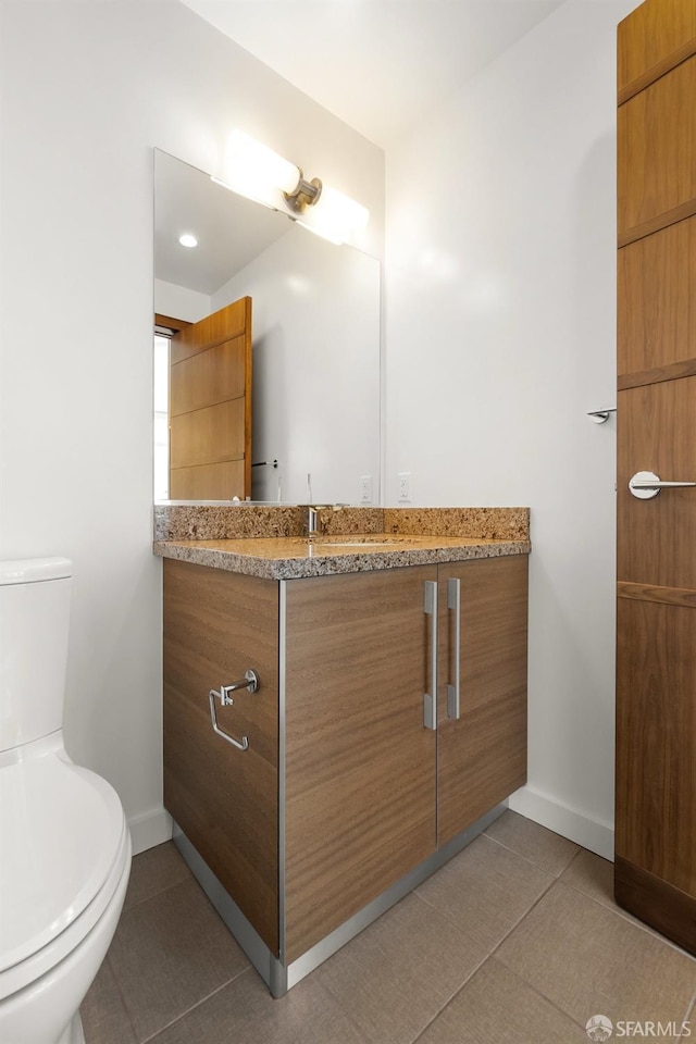 bathroom featuring tile patterned flooring, vanity, and toilet