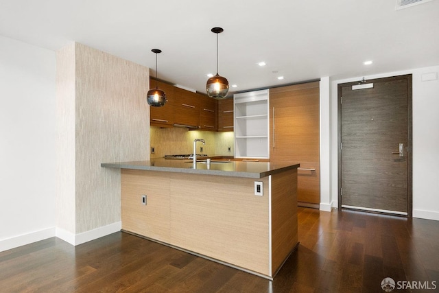 kitchen with sink, hanging light fixtures, dark hardwood / wood-style flooring, decorative backsplash, and kitchen peninsula