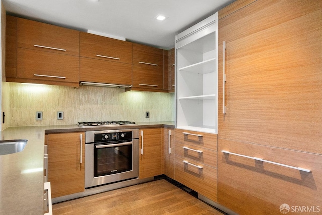 kitchen featuring decorative backsplash, light hardwood / wood-style floors, and appliances with stainless steel finishes