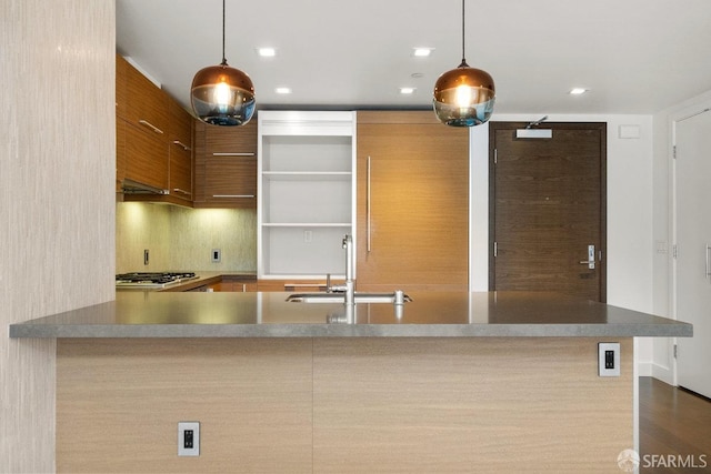 kitchen featuring sink, pendant lighting, dark hardwood / wood-style flooring, and kitchen peninsula