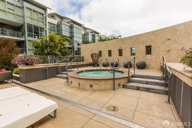 view of swimming pool featuring a hot tub and a patio area