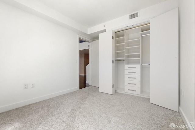 unfurnished bedroom with a closet and light carpet