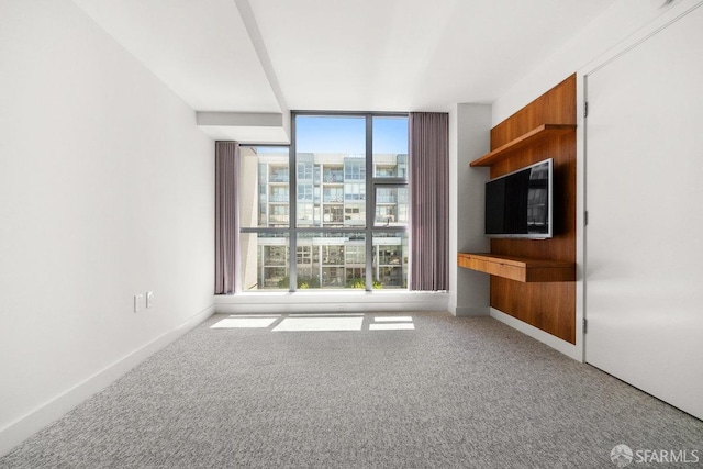 unfurnished living room with light colored carpet and built in desk