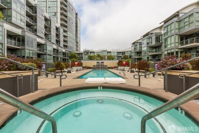 view of pool with a community hot tub and a patio