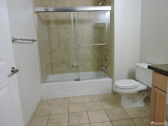 full bathroom with shower / bath combination with glass door, vanity, toilet, and tile patterned floors