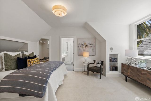 bedroom with carpet, lofted ceiling, baseboards, and ensuite bath