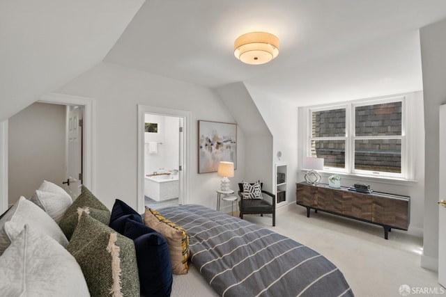 carpeted bedroom featuring lofted ceiling and connected bathroom