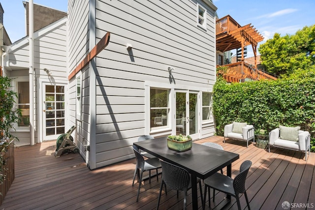 deck featuring outdoor lounge area, french doors, and outdoor dining space