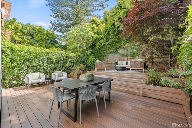deck featuring an outdoor hangout area, fence, and outdoor dining area