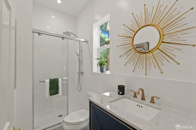 bathroom with a stall shower, toilet, tile walls, and vanity