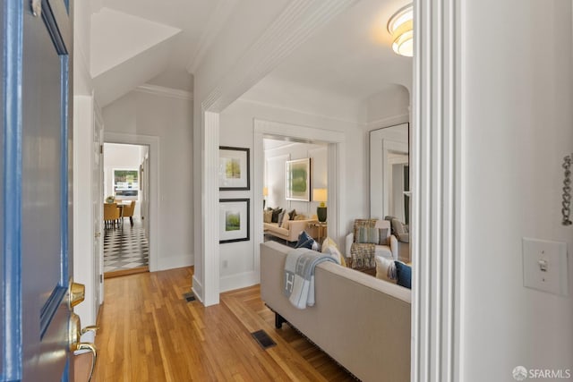living room with light wood-style floors, baseboards, and crown molding