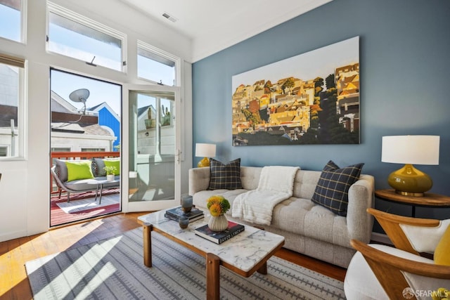 living area featuring visible vents and wood finished floors