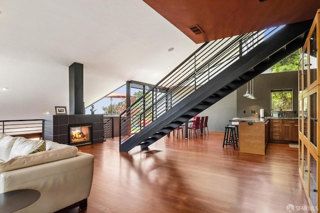 6353 Skyline Blvd, Oakland, CA 94611 - living room featuring wood finished floors, stairway, and a tiled fireplace
