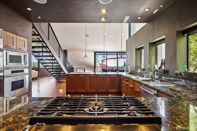 6353 Skyline Blvd, Oakland, CA 94611 - kitchen featuring appliances with stainless steel finishes, dark stone counters, wood finished floors, a high ceiling, and recessed lighting
