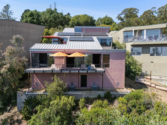6353 Skyline Blvd, Oakland, CA 94611 - back of property featuring solar panels, a standing seam roof, a balcony, central AC unit, and metal roof