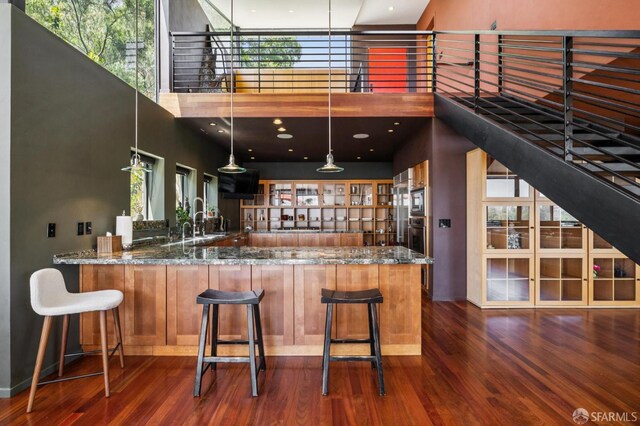 6353 Skyline Blvd, Oakland, CA 94611 - bar with a towering ceiling, wood finished floors, baseboards, appliances with stainless steel finishes, and a sink