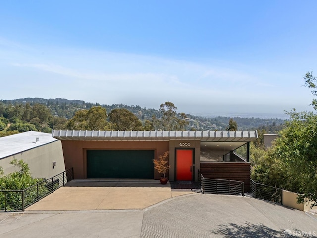 6353 Skyline Blvd, Oakland, CA 94611 - view of front of house with a garage, concrete driveway, and stucco siding