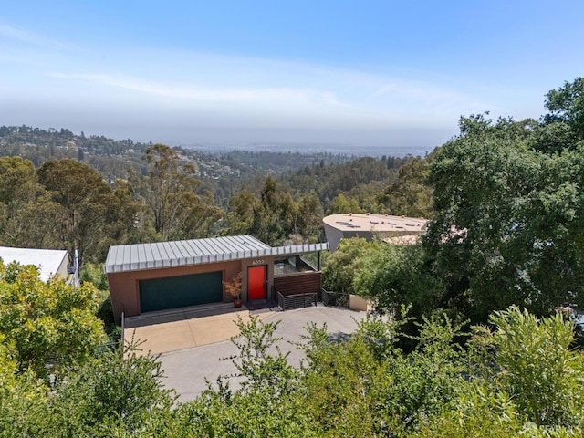 6353 Skyline Blvd, Oakland, CA 94611 - garage featuring a forest view and concrete driveway