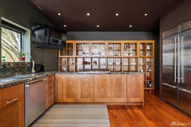 6353 Skyline Blvd, Oakland, CA 94611 - kitchen with appliances with stainless steel finishes, wood finished floors, glass insert cabinets, dark stone countertops, and brown cabinetry