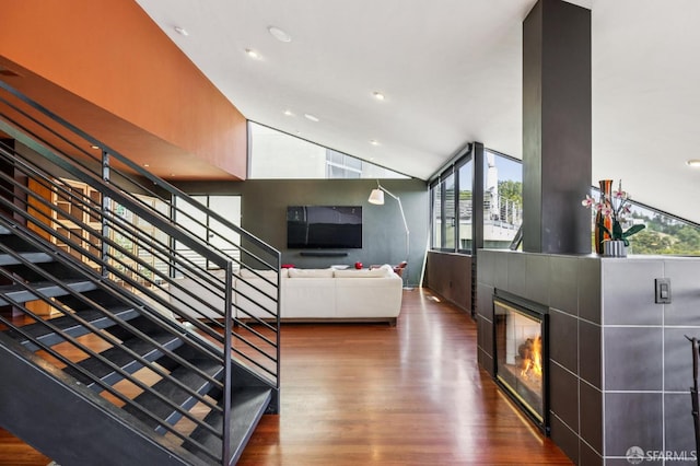 6353 Skyline Blvd, Oakland, CA 94611 - stairway featuring wood finished floors, healthy amount of natural light, vaulted ceiling, a tile fireplace, and recessed lighting